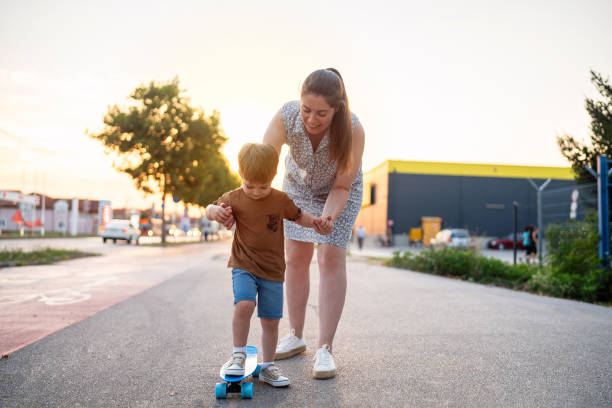 istock Mother teaching son to skateboard 1693430135