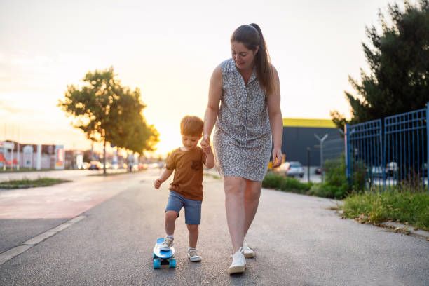 istock Mother teaching son to skateboard 1693430156