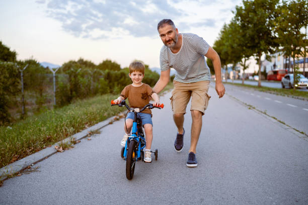 istock Father teaching his son to ride a bicycle 1693431137