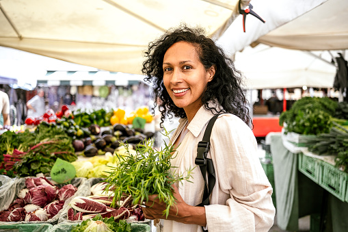 Woman buying vegetables at the open food market
