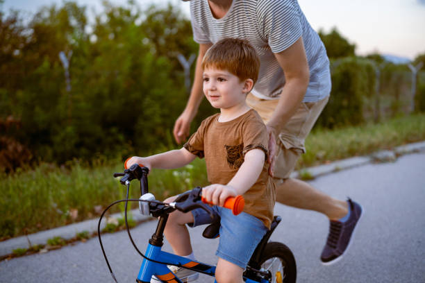 istock Father teaching his son to ride a bicycle 1693431381