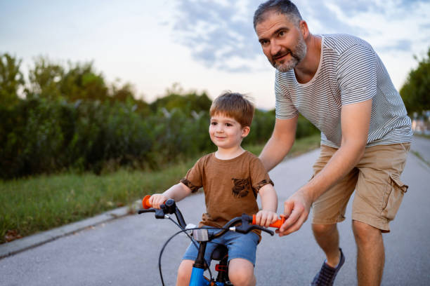 istock Father teaching his son to ride a bicycle 1693431384