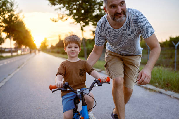 istock Father teaching his son to ride a bicycle 1693431396