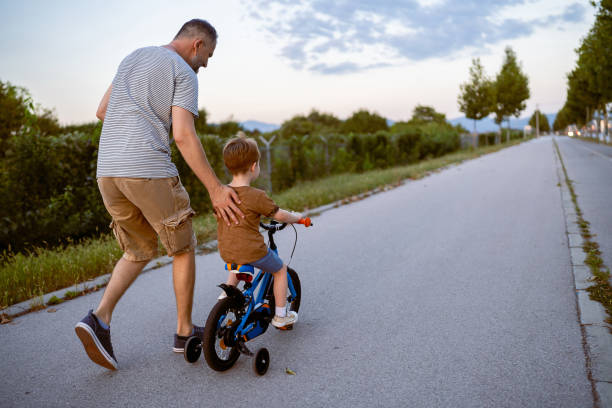 istock Father teaching his son to ride a bicycle 1693431629