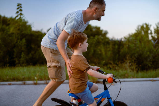 istock Father teaching his son to ride a bicycle 1693431632