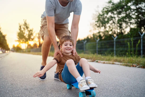 istock Father riding his son on a skateboard 1693432851