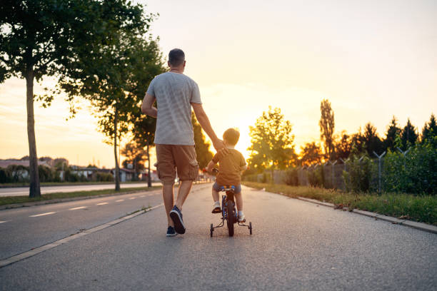 istock Father teaching his son to ride a bicycle 1693436454