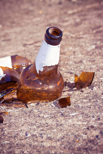 istock Shattered beer bottle resting on the ground - alcoholism concept - Image with copy space 1693441517