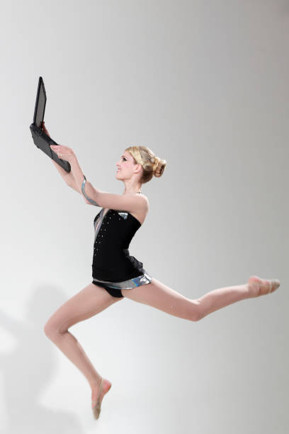 istock Rhytmic gymnastics jump with laptop 1693442663