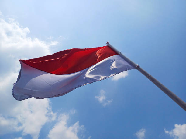 istock Indonesian red and white flag flying in the sky 1693443915