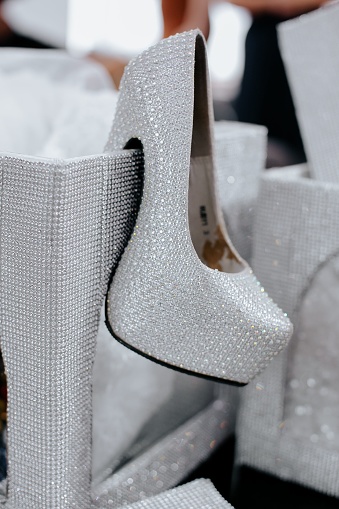A closeup of a sparkling silver shoe with diamonds.