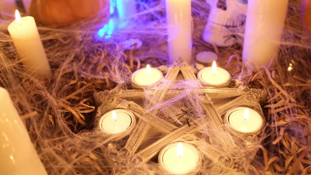 Close up, mysterious pentagram with flickering candles and traditional pumpkins approaching tracking shot.