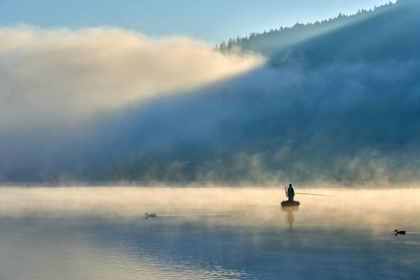 The folding chair and feeder on the pier in summer at sunrise in the fog