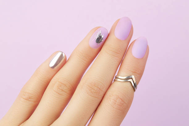 istock Close up womans hand with matte lavender and silver nails. Beauty treatment 1693466488