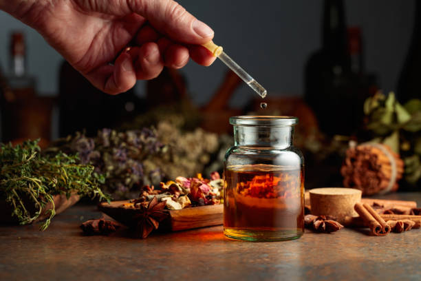 istock Dropping essential herbal tincture into a small glass bottle. 1693479204