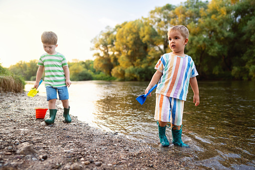 Two little boys enjoying a carefree summer day by the river.