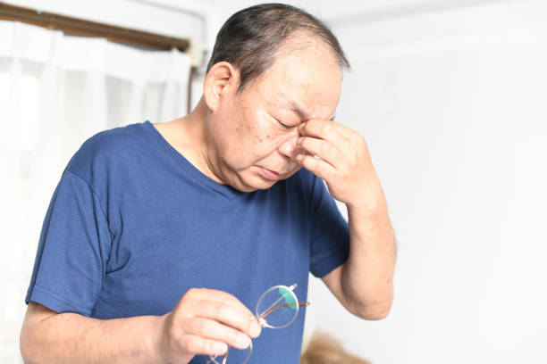istock Asian elderly man with tired eyes taking off glasses 1693487239