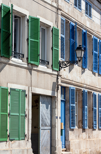 old facade with green and blue shutters in small french burgundy town