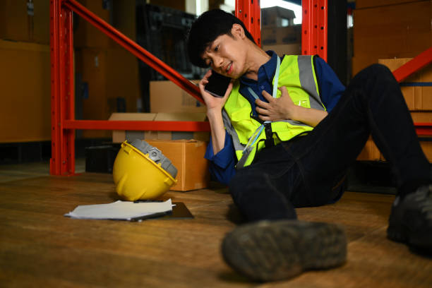 istock Warehouse worker making an emergency call, asking for first aid team after accident. Injury at work 1693492928