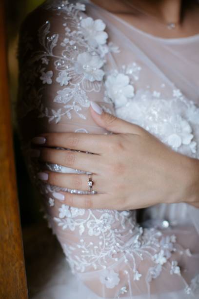 istock Closeup of a bride displaying her diamond engagement ring. 1693493763