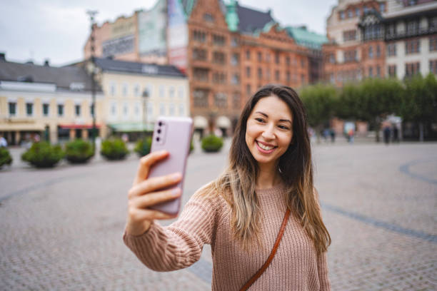 istock Beautiful female tourist taking selfies while exploring the city 1693493908