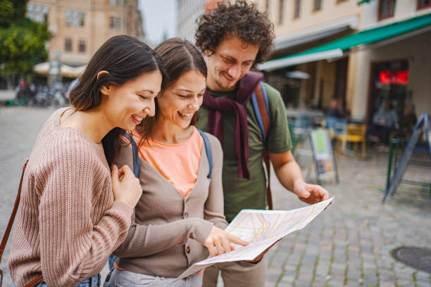 istock Three happy tourists looking at a map while exploring the city of Malmo 1693493986