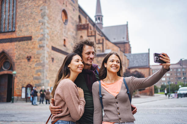 istock Three happy tourists taking selfies while exploring the city of Malmo 1693494794