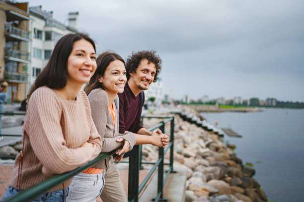 istock Three friends spending time relaxing near the coastline looking at the view 1693497729