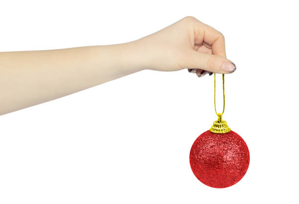 istock Christmas tree toy in outstretched hand isolated from background, Christmas tree decoration concept 1693508406