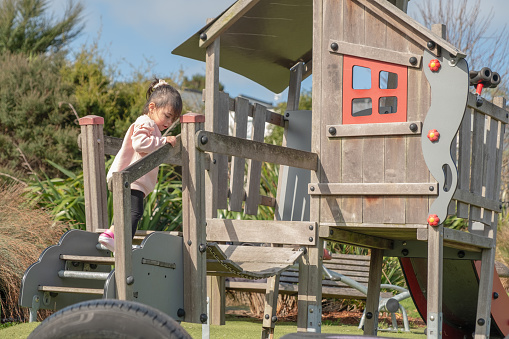 A young girl climbing up to her playhouse