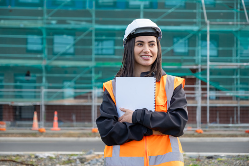 A female engineer standing confidently with arms folded