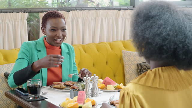 African businesswomen enjoying breakfast at restaurant