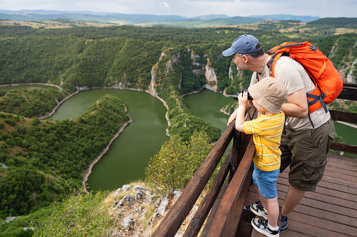 Father and son looking at the canyon of meandering river Uvac in southwestern Serbia.