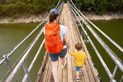 Mother and son on an adventure, crossing a suspension bridge over the Uvac river.