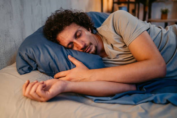Young Man Sleeping In The Bed At Night