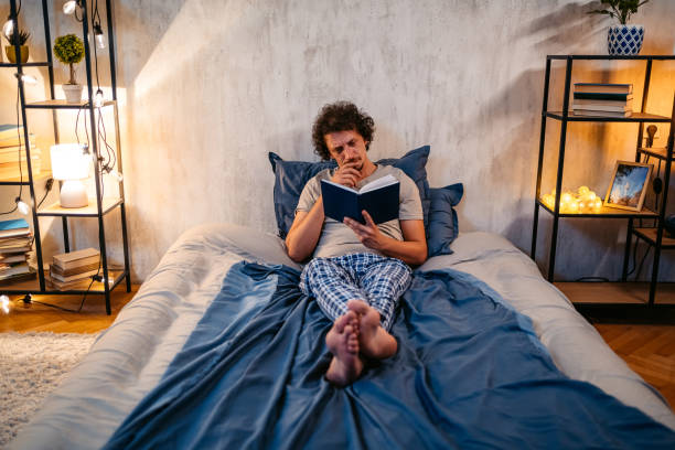 istock Young Man Reading A Book In The Bed At Night 1693537044