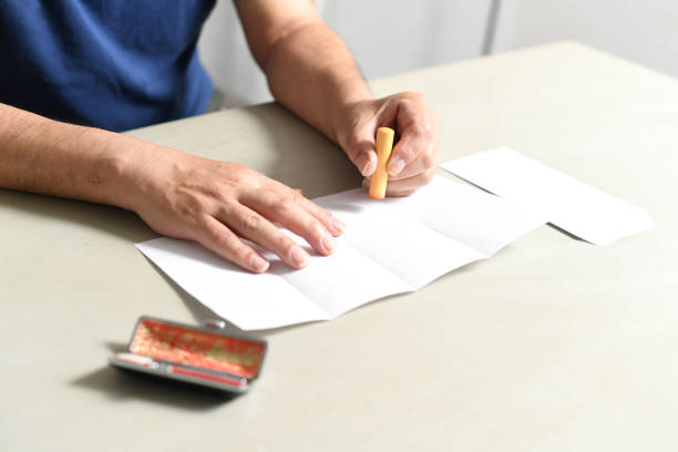 istock Hand of an elderly Asian man stamping a document 1693541144