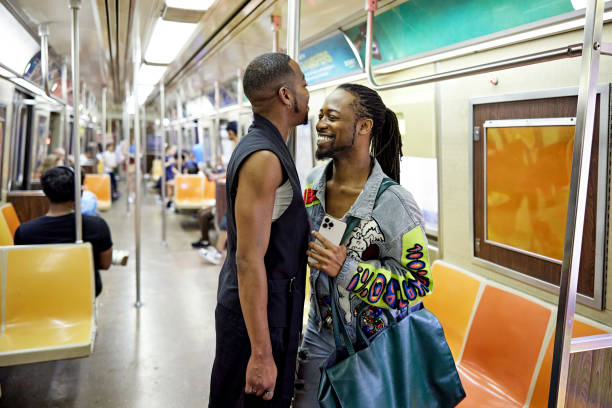 istock Smiling gay couple standing on subway train 1693548504