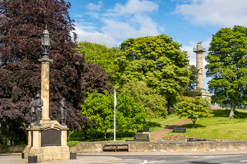 Grade 2 listed war memorial at Alnwick in Northumberland, with the Percy Tenantry Column in the background.