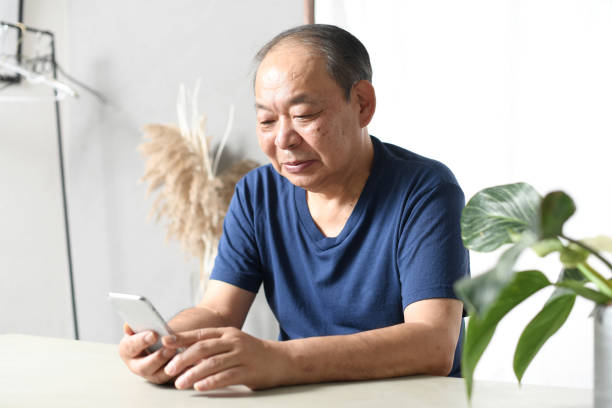 istock Asian senior man operating a mobile phone with a smile 1693570775