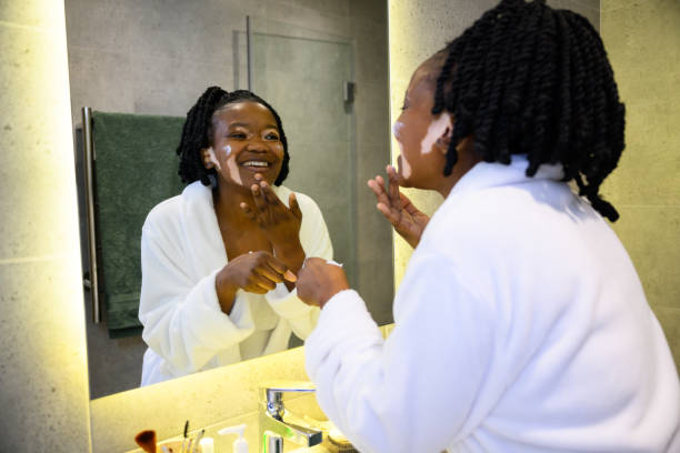 istock Happy young woman with vitiligo skin condition using moisturiser in bathroom 1693572964