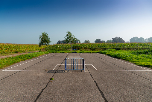 Sunlit soccer court outside village, surrounded by cornfields. The Netherlands.