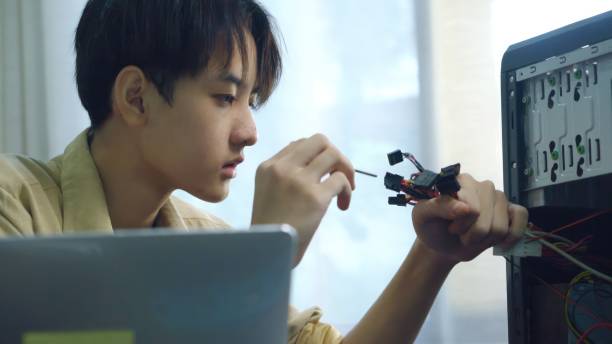 istock Asian young boy learning to repair computer and electronic board in the classroom.  Engineering electronic education in colleges. 1693619906