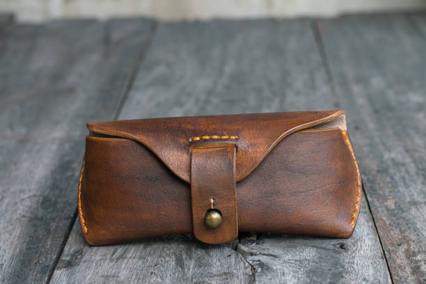 istock Brown genuine leather glasses handmade case on wood background 1693666527