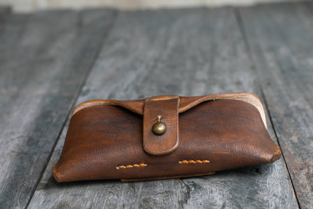 istock Brown genuine leather glasses handmade case on wood background 1693668393