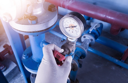 Checking the water pressure in the system for analysis by an engineer. The engineer hold the  valve gate  to open water pressure  line to gauge measurment.