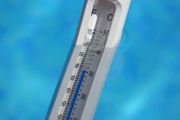 Water thermometer reading the swimming pool temperature at 30 Celsius