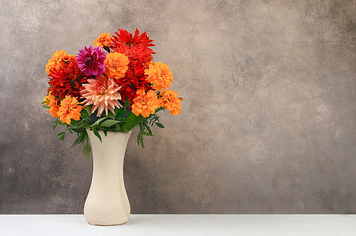 Beautiful dahlia flowers in a vase, abstract floral arrangement, autumn background with space for text, minimal holiday concept, still life, postcard. Happy birthday, wedding, selective focus