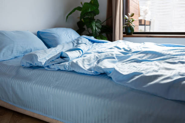 istock Close up of blue stripe satin bedding clothes on bed 1693694460