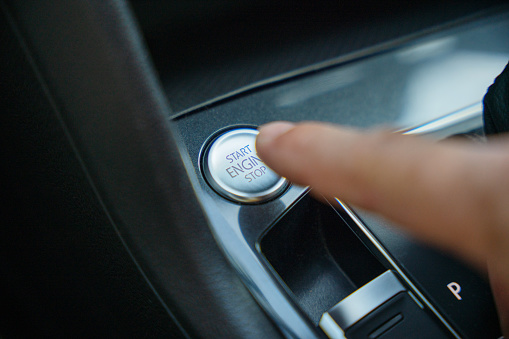 Start engine button. Male finger pushing start engine button of the car